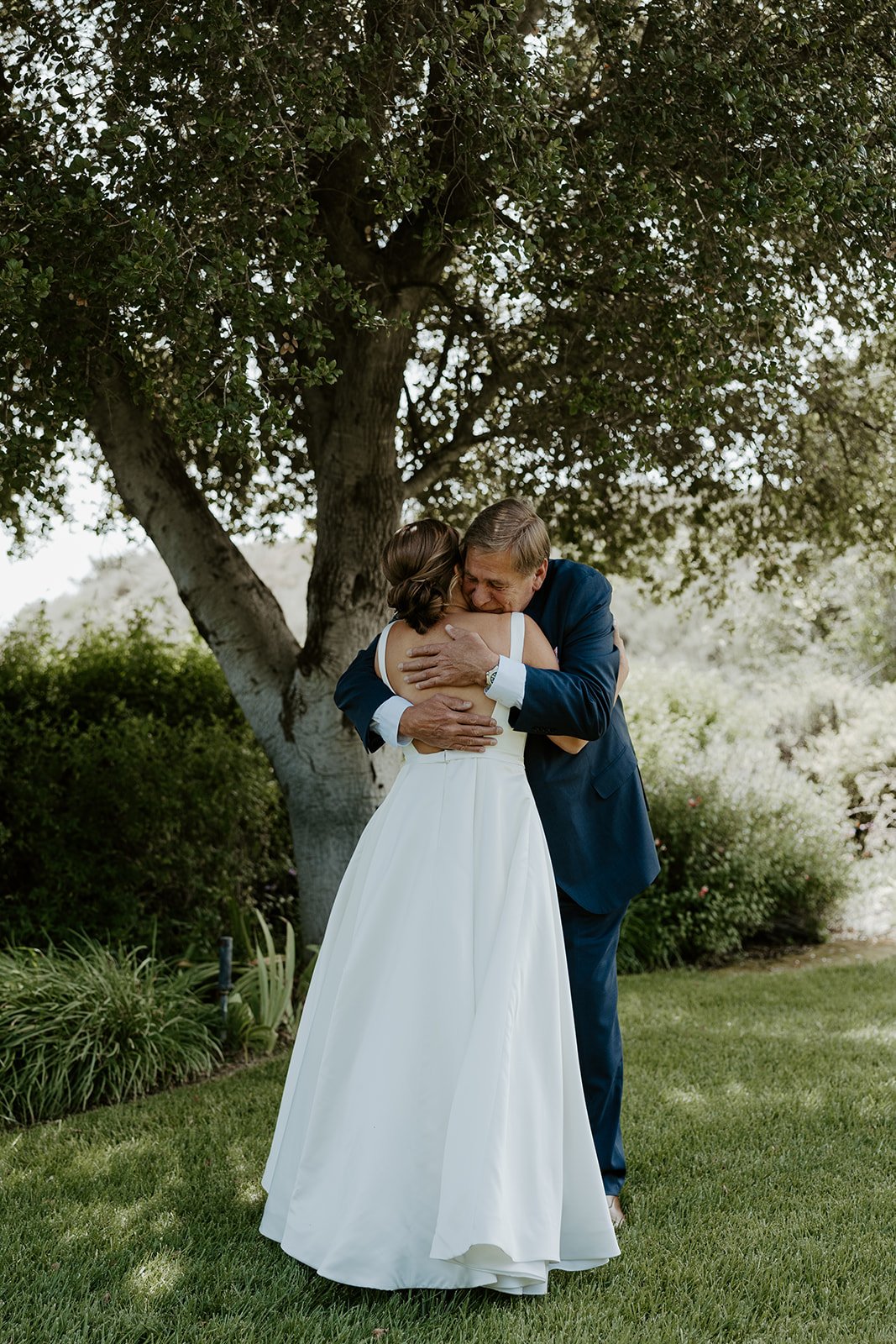 A bride hugging her dad during a wedding first look