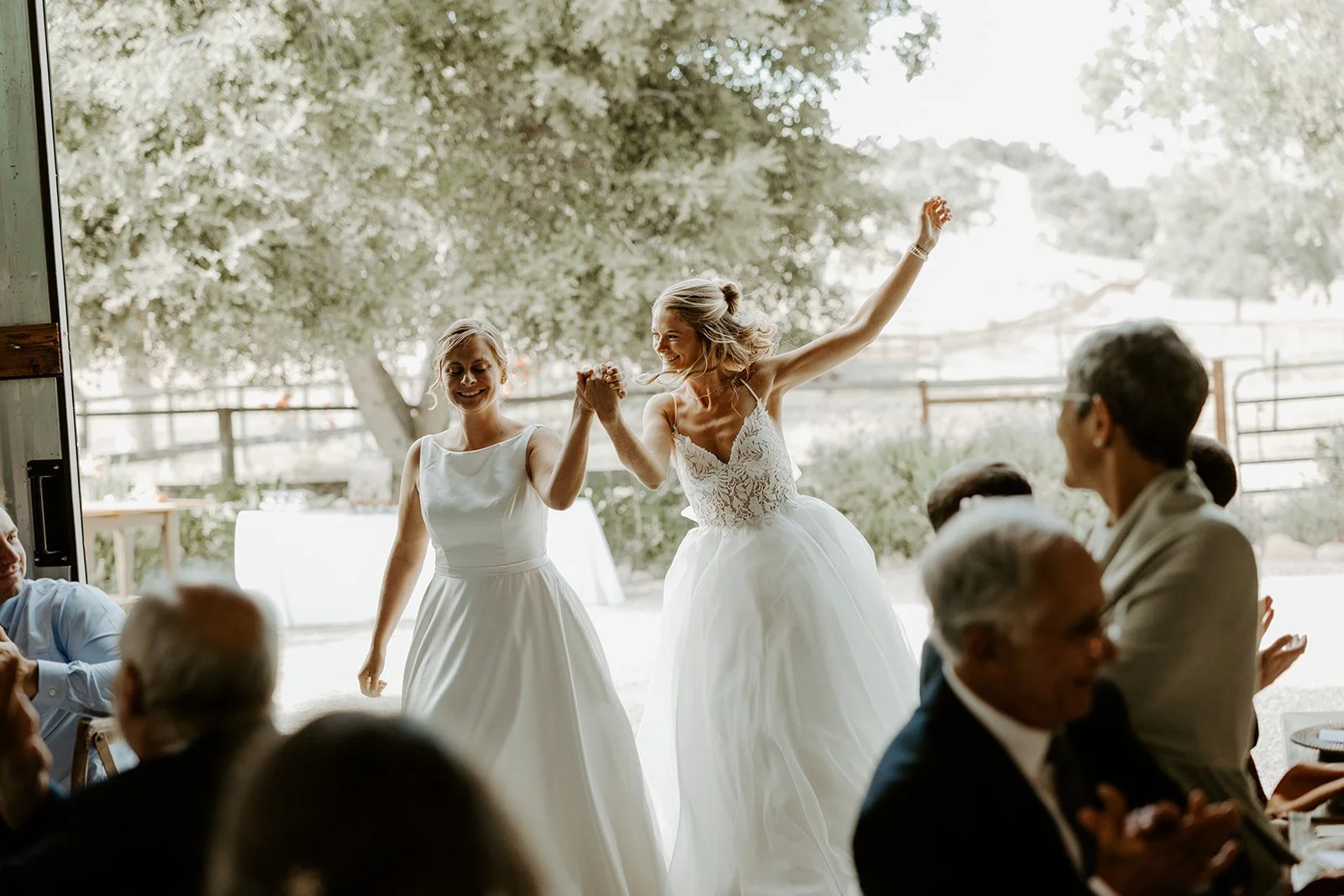 Brides cheering while entering their wedding reception