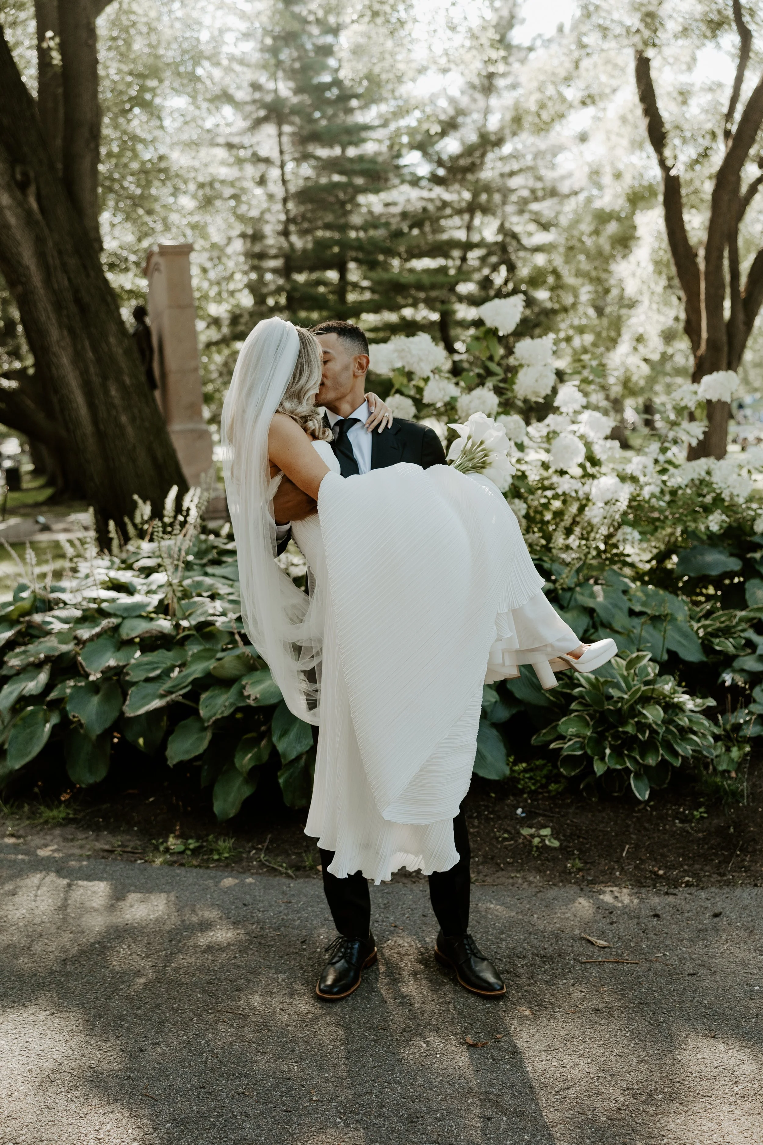 A man lifting up his bride to kiss her in elopement photos