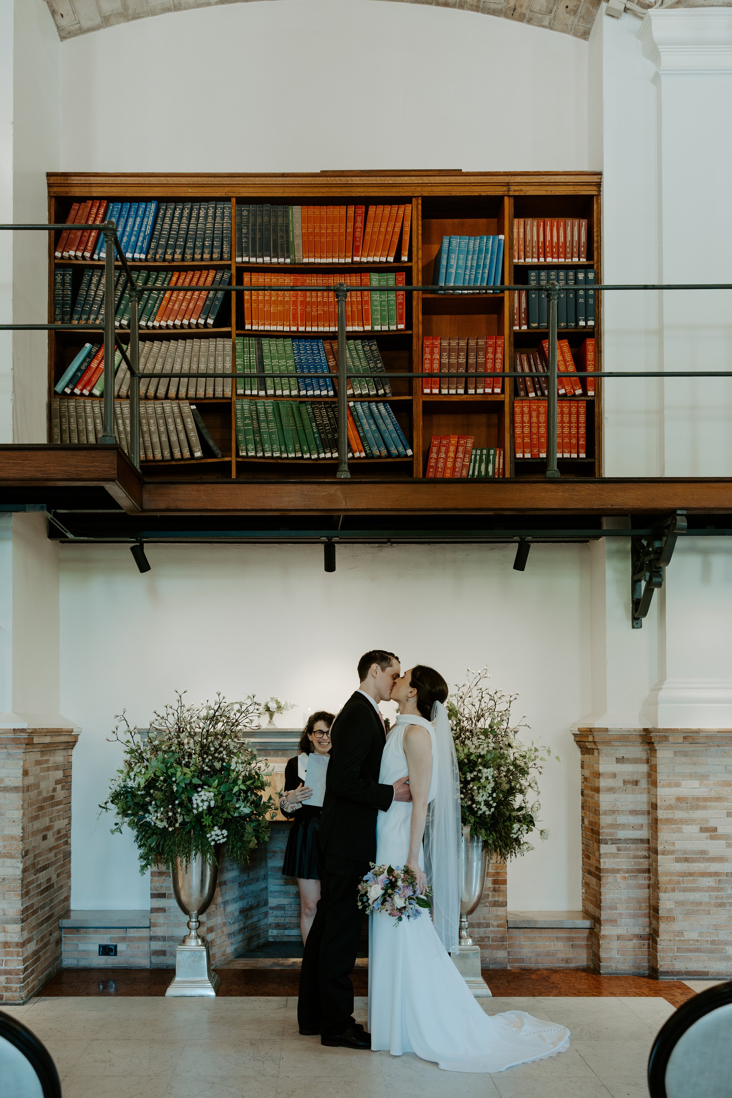 A couple sharing their first kiss at their library elopement location