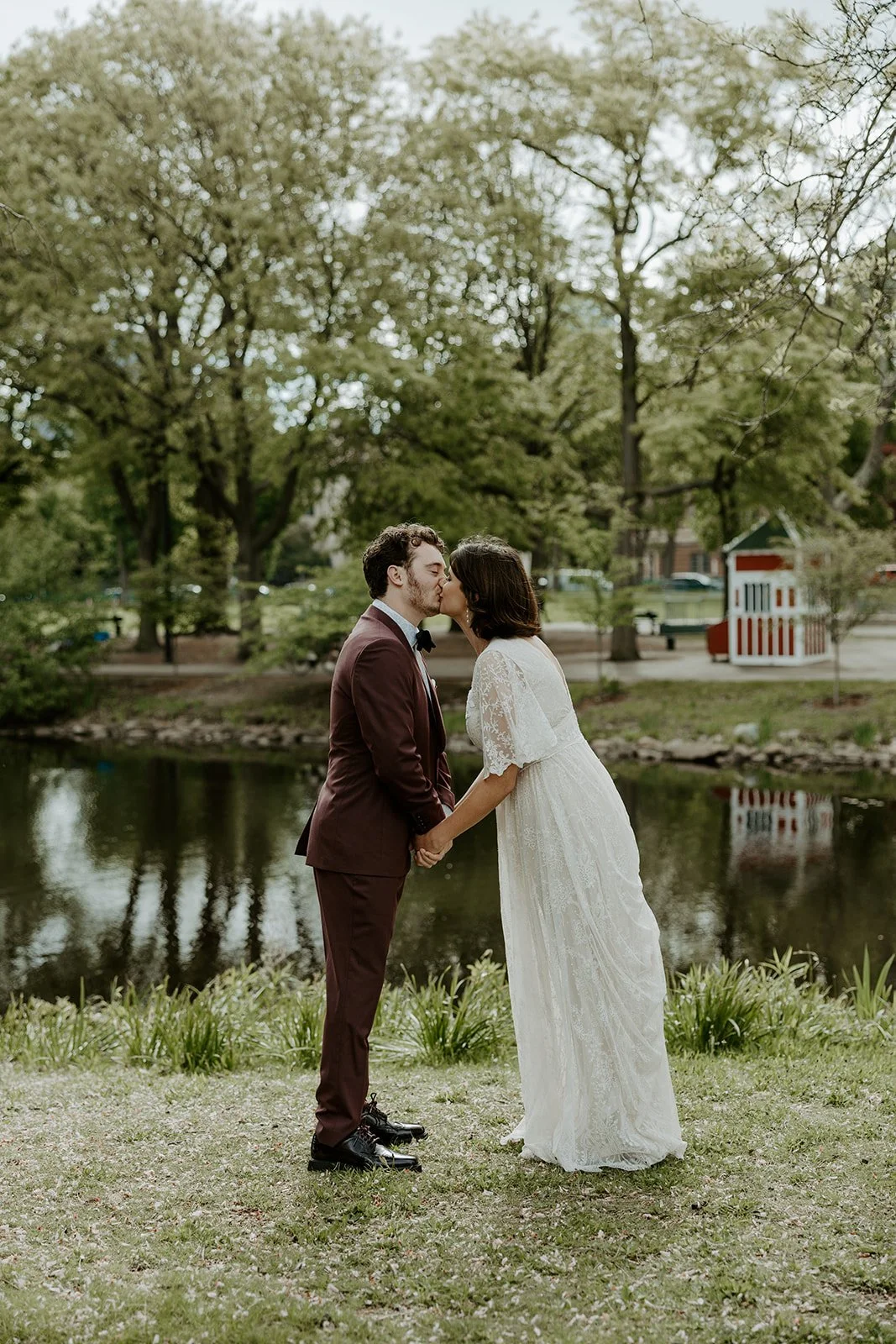 A couple kissing in front of the pond at their elopement location, the Esplanade