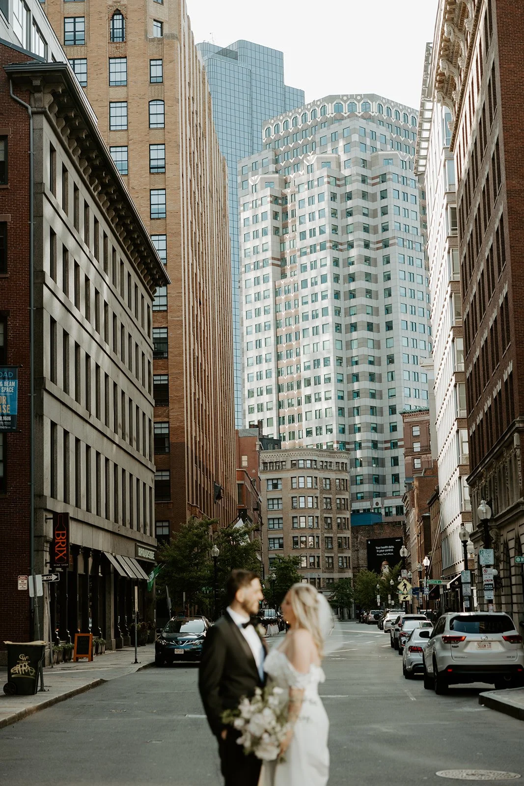 A couple posing for photos on a city street before their boston elopement