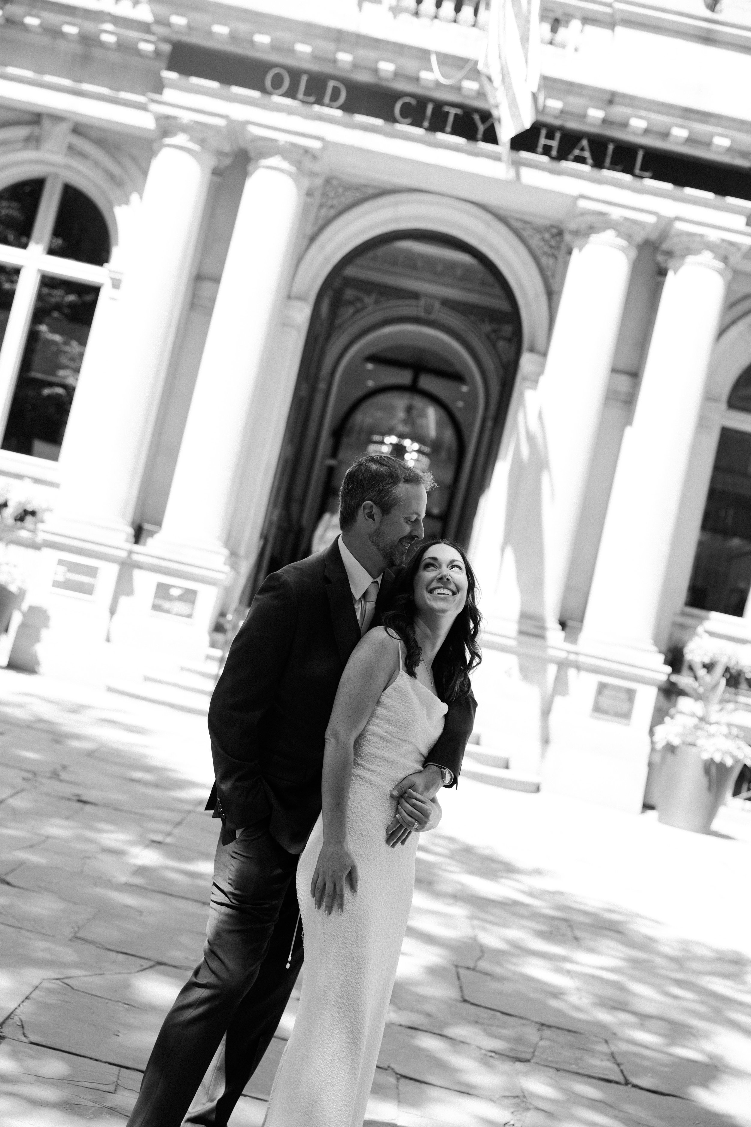A couple posing in front of city hall for their Boston elopement