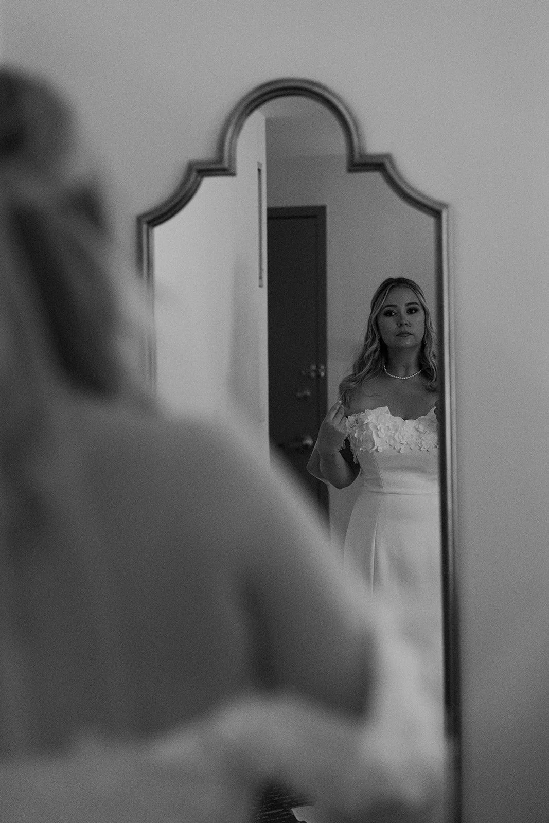 A bride looking in the mirror, getting ready for her elopement