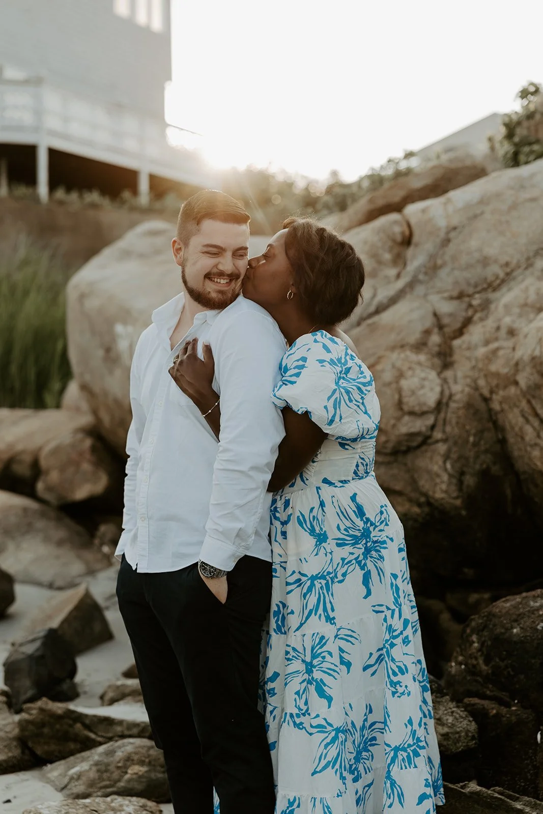 A girl kissing her fiance on the cheek during engagement photos