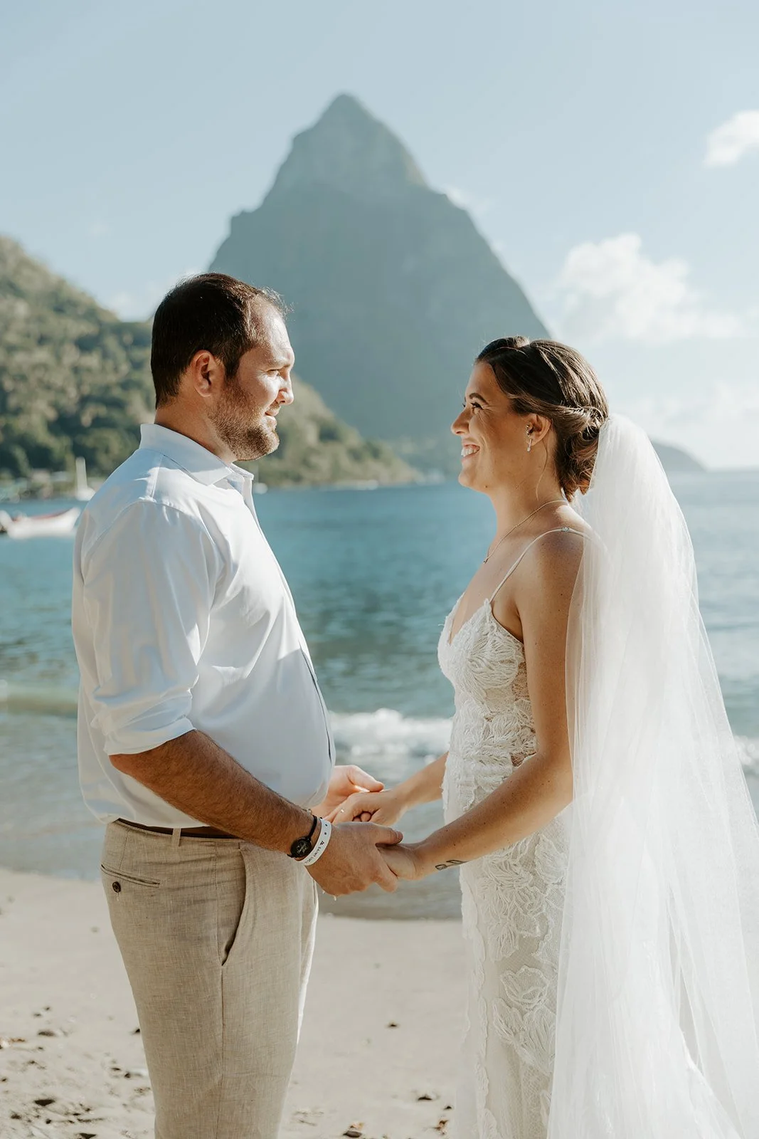 A wedding couple smiling at each other on the beach in St Lucia