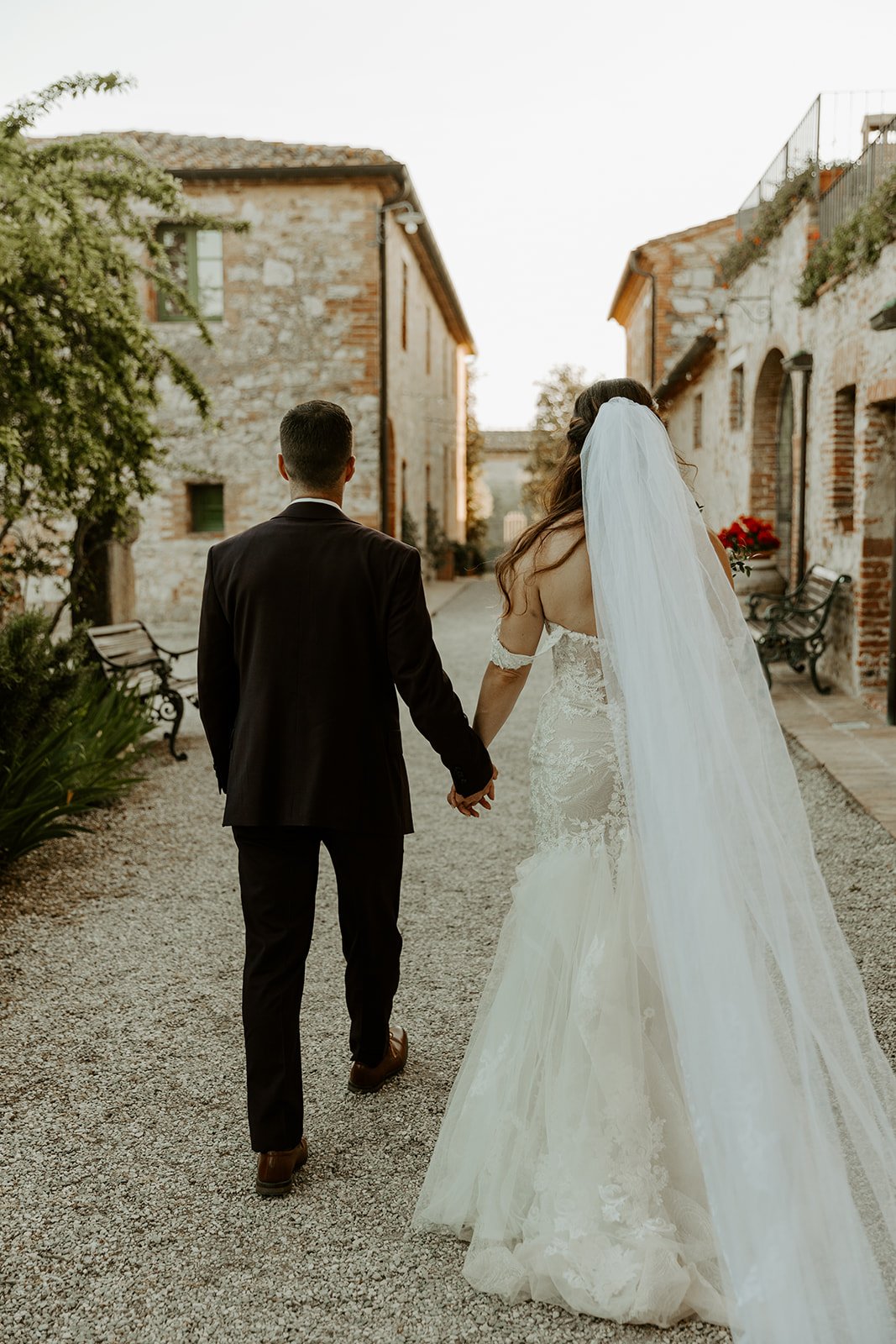 A couple holding hands walking through the streets of italy, their destination wedding location