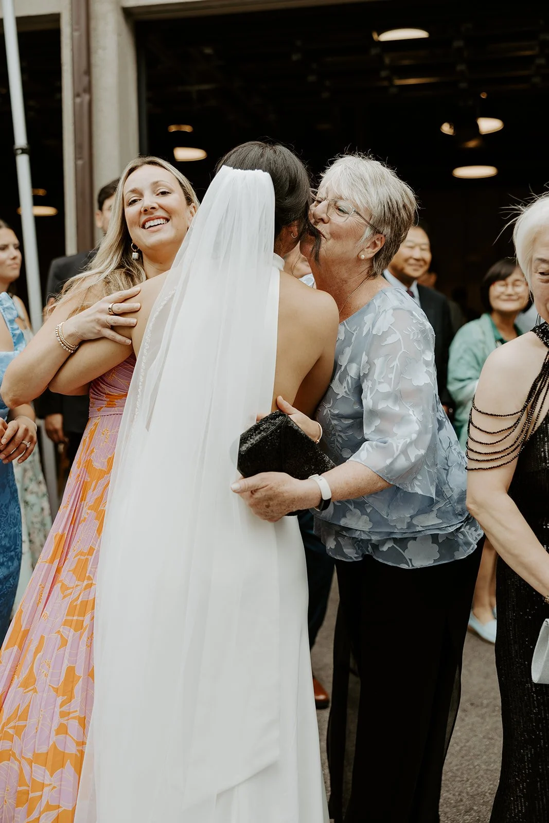 A bride hugging wedding guests during cocktail hour