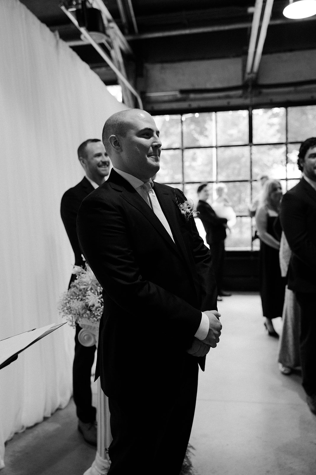 A groom watching his bride walk down the aisle