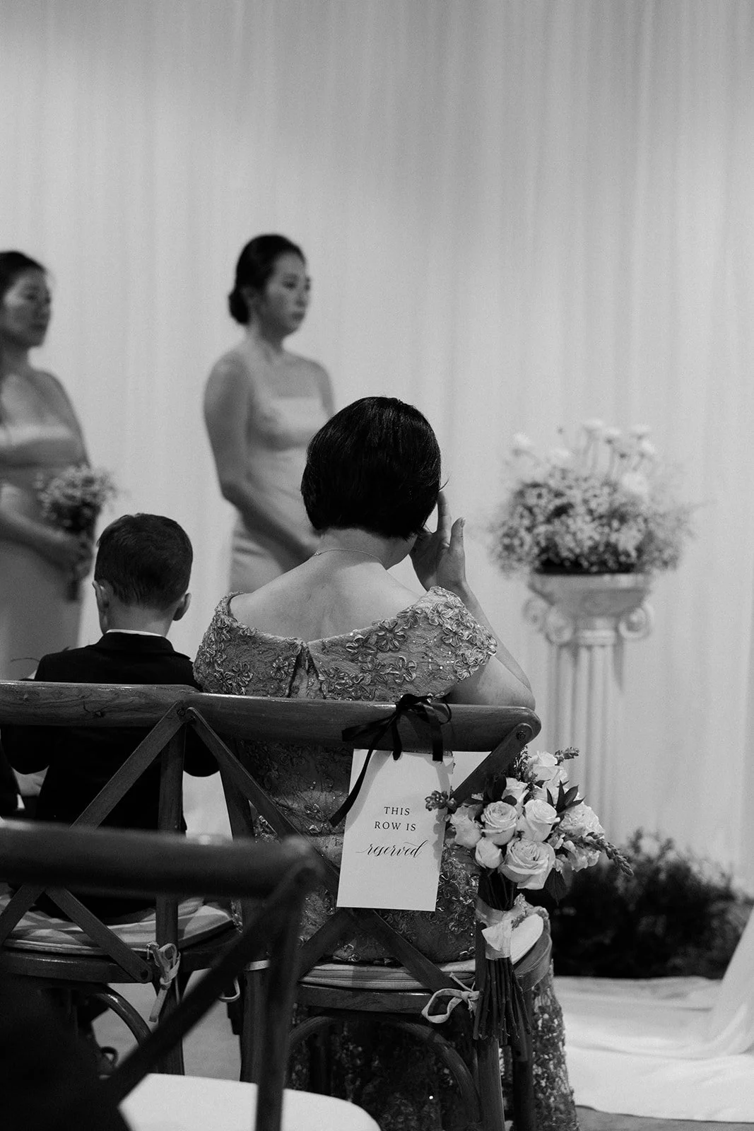 The mother of the bride crying during her daughter's wedding ceremony at garage b