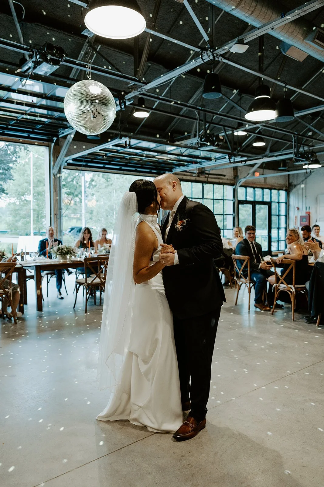 A bride and groom kissing during their first dance