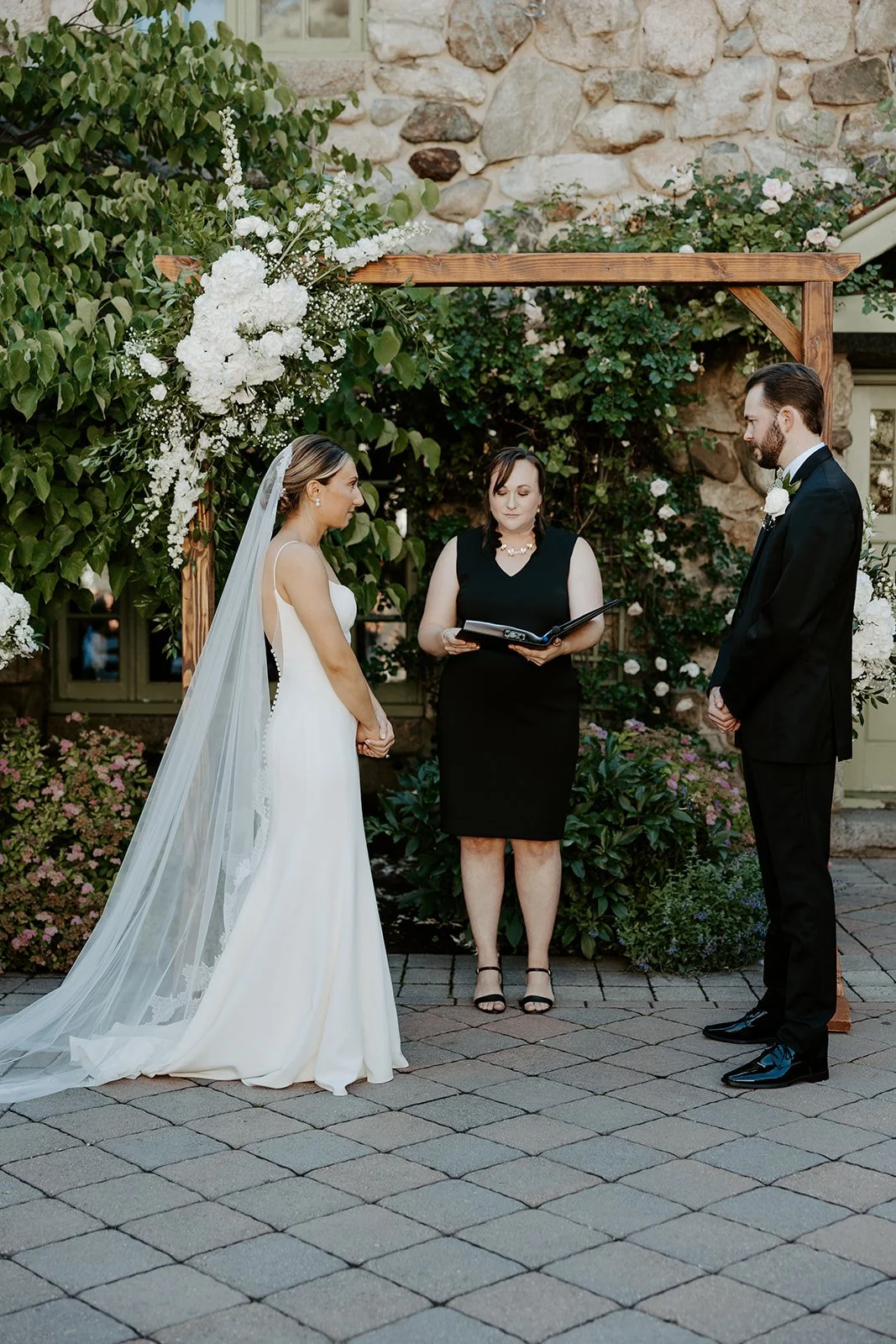A bride and groom holding hands during an outdoor wedding ceremony