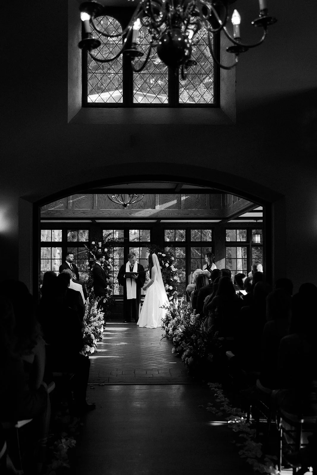 A black and white photo taken by a Massachusetts wedding photographer of an indoor wedding ceremony