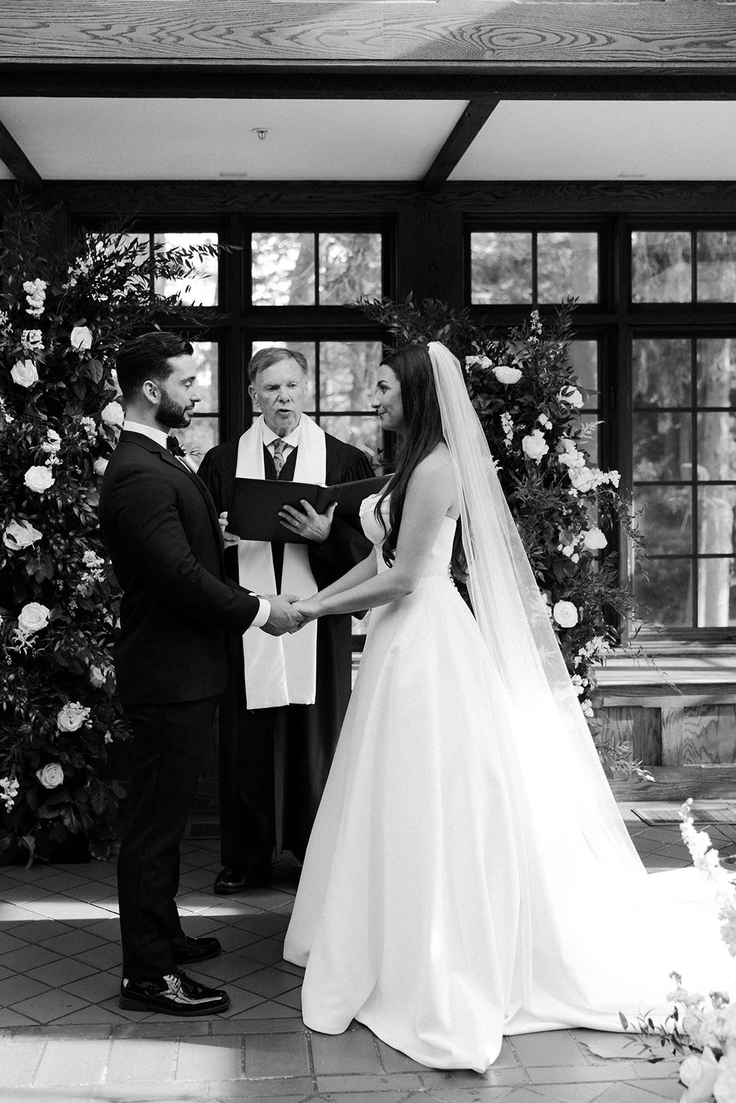 A black and white photo taken by a Massachusetts wedding photographer of an indoor wedding ceremony