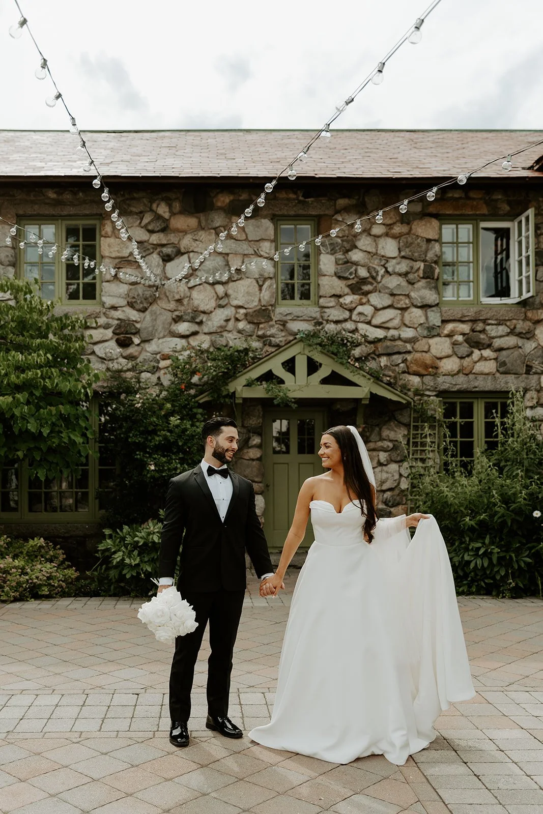 A bride and groom posing for wedding photos in front of willowdale estate