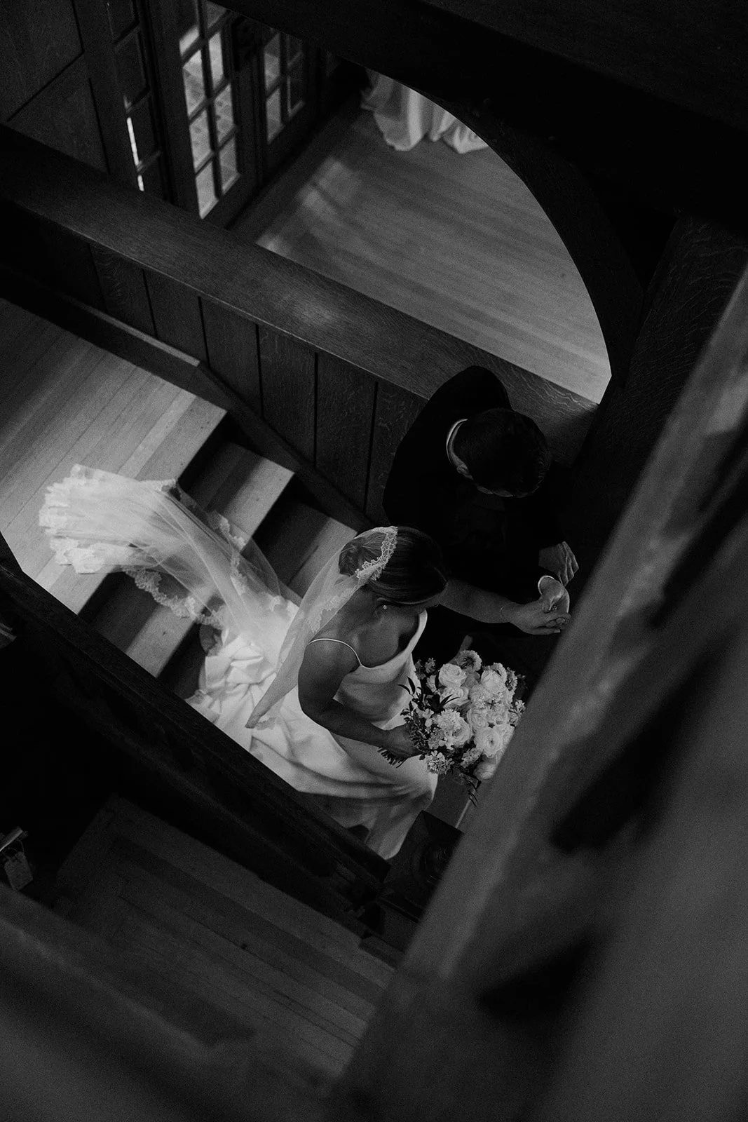 A bride and groom walking down stiars inside of a mansion wedding venue