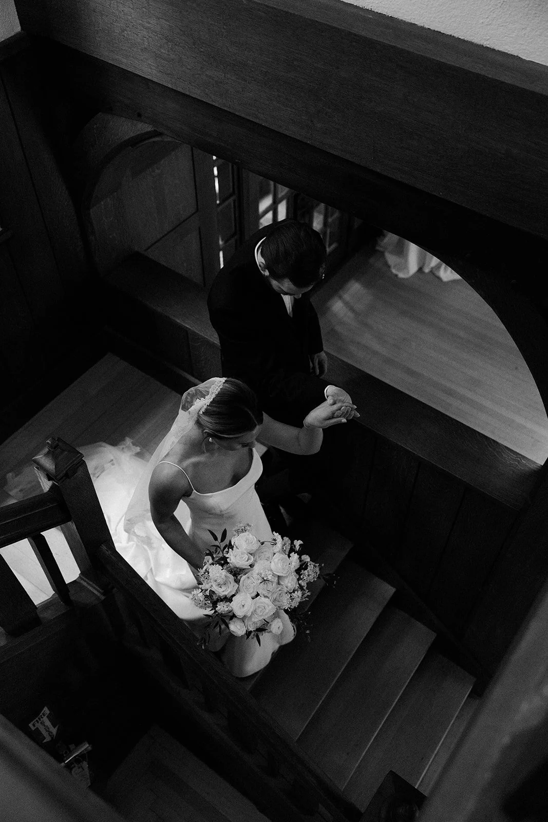 A bride and groom walking down stiars inside of a mansion wedding venue