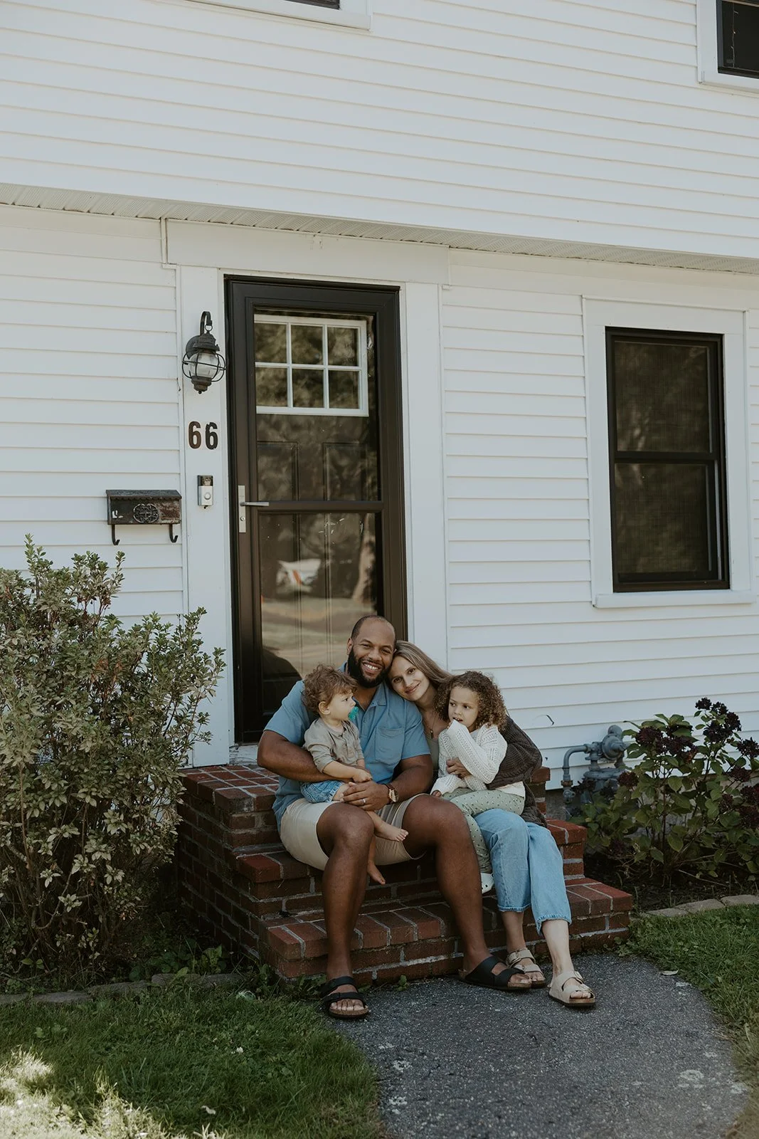 A family on the front steps of their house for family photos at home