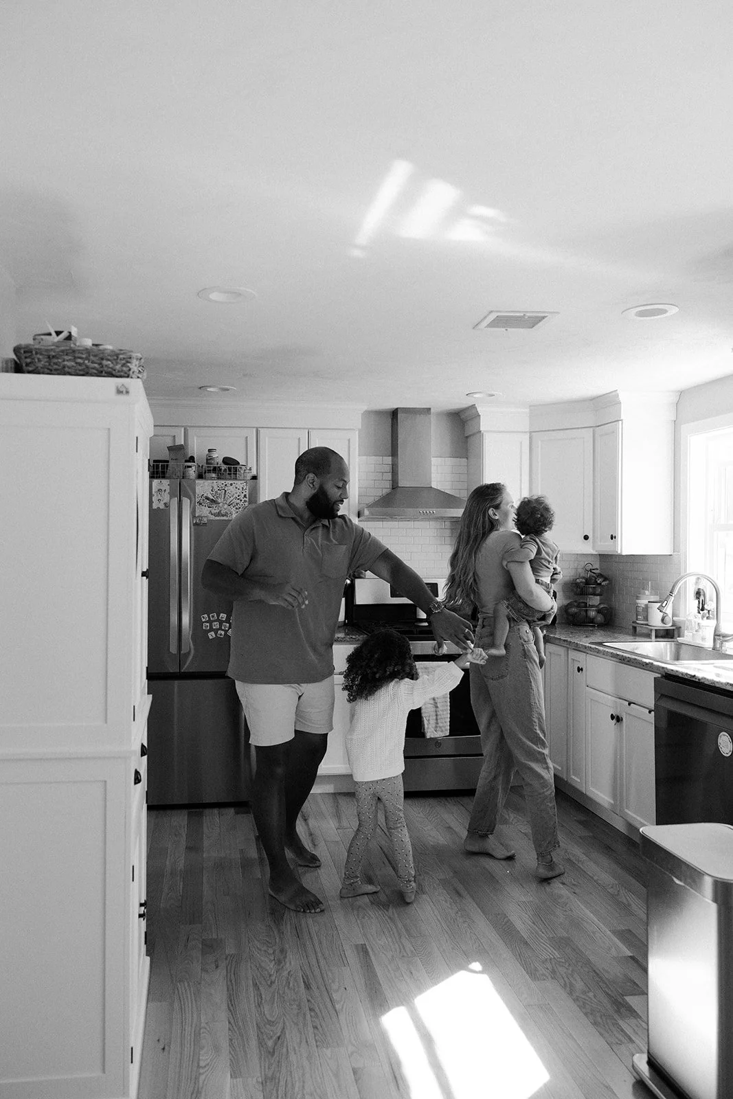 A family dancing in the kitchen during at home family photos