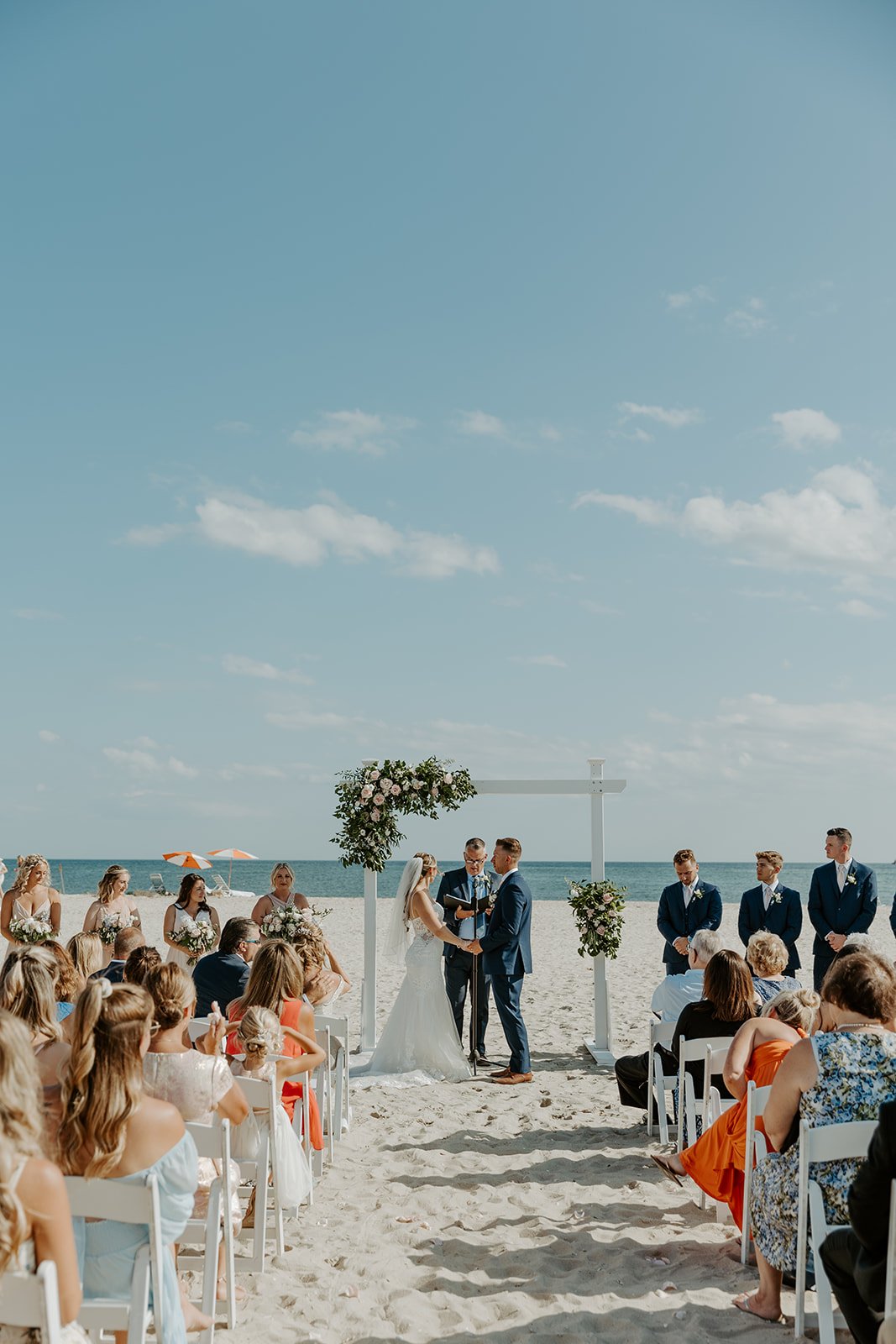 A wedding ceremony taking place on the beach at Wychemere Beach Club