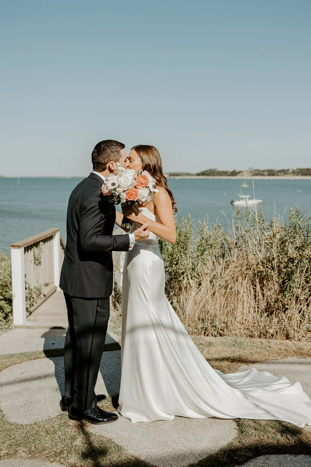A bride and groom kissing after their first look at a cape cod wedding