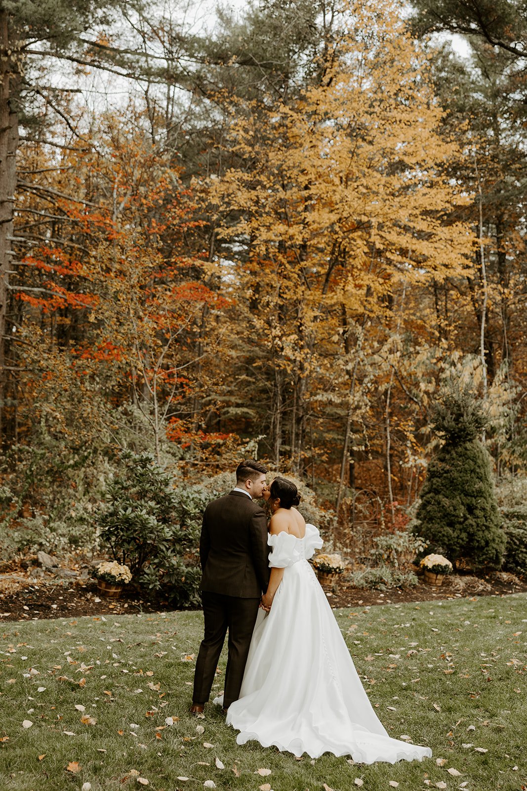 A bride and groom taking portraits for their fall wedding at bedford village inn