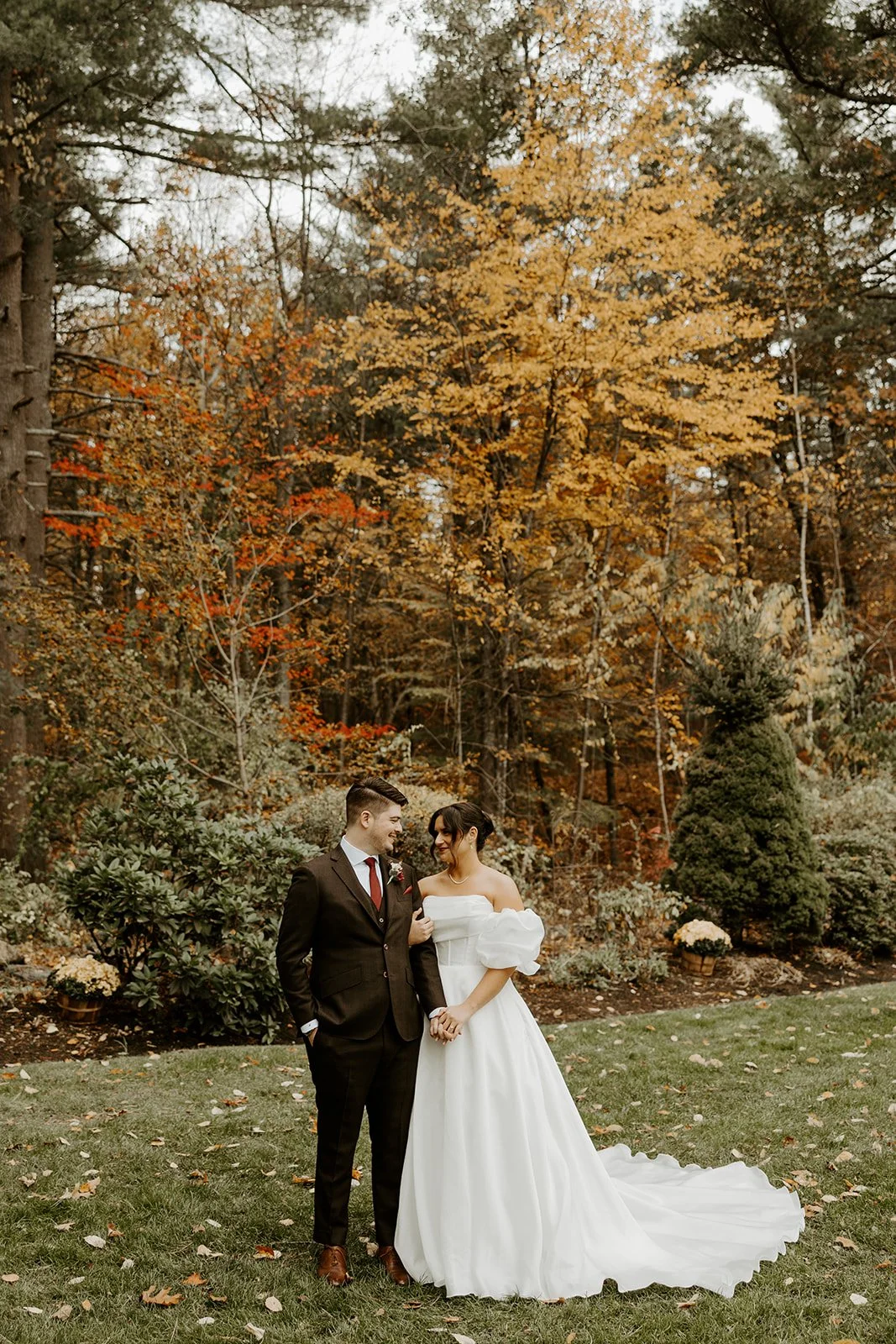 A bride and groom taking portraits for their fall wedding at bedford village inn