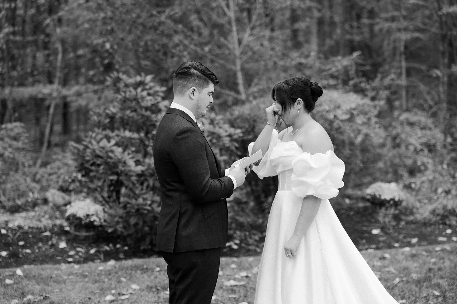A bride crying while a groom reads private vows