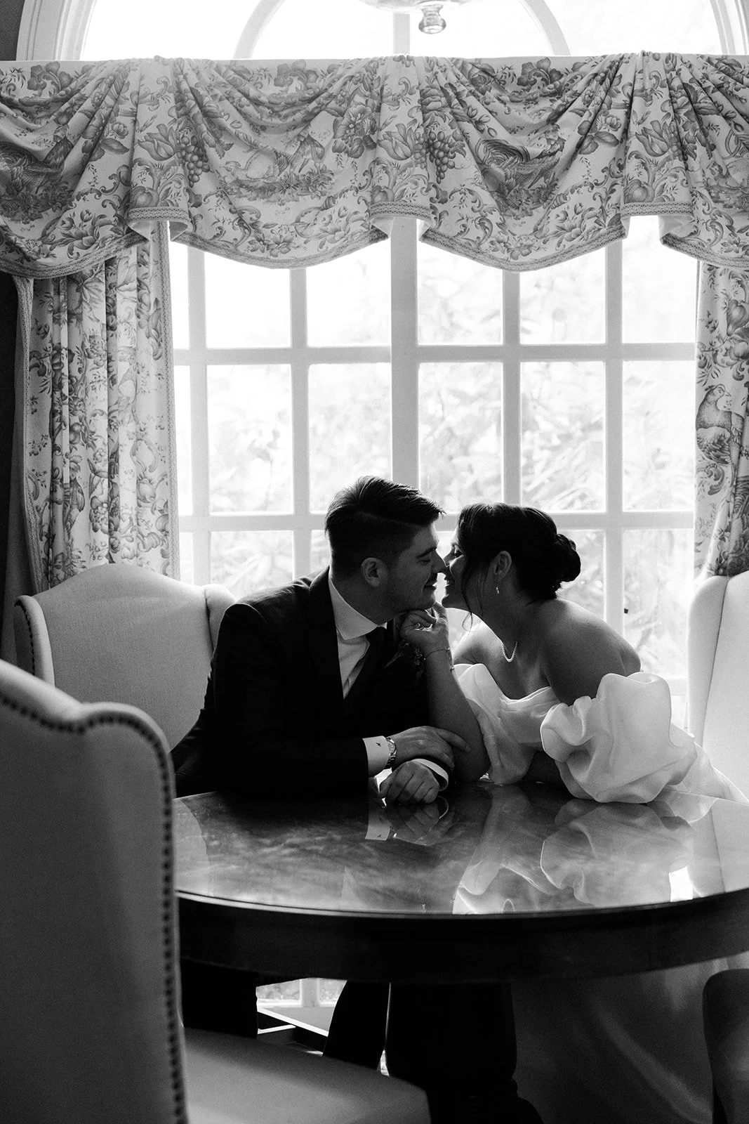 A bride and groom kissing inside of the Bedford Village Inn