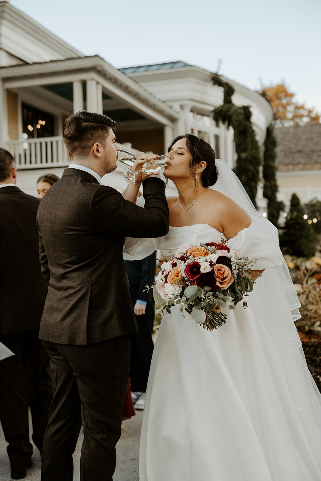 A bride and groom sharing champagne after their wedding ceremony
