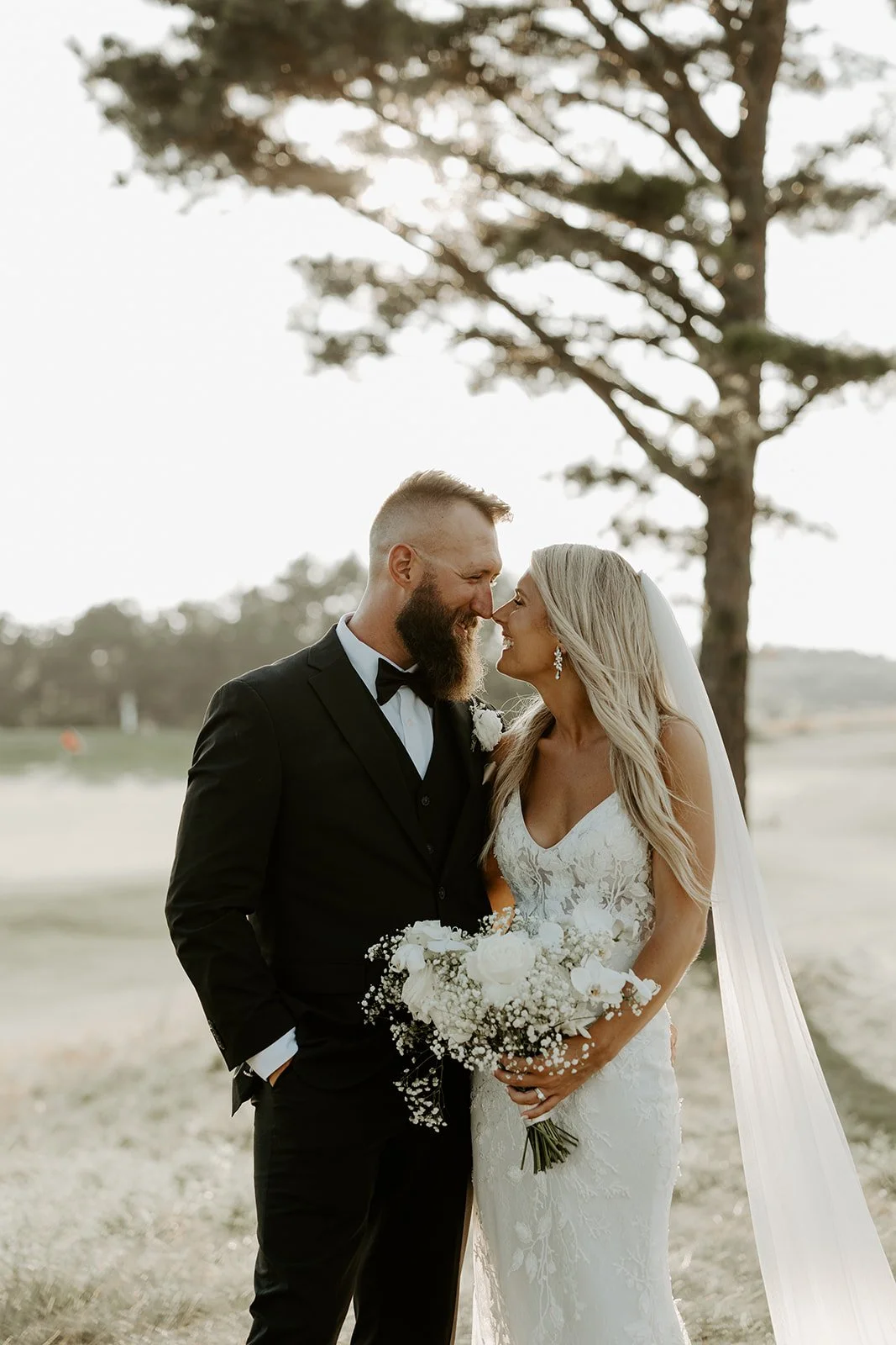 A bride and groom laughing while taking sunset photos
