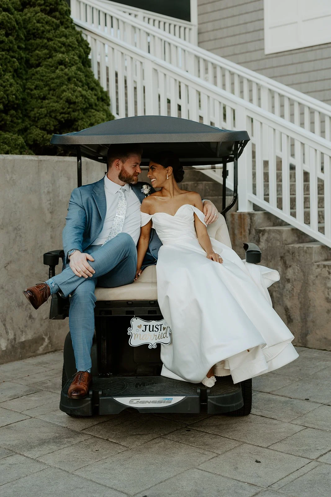 A bride and groom kissing on a golf cart at waverly oaks
