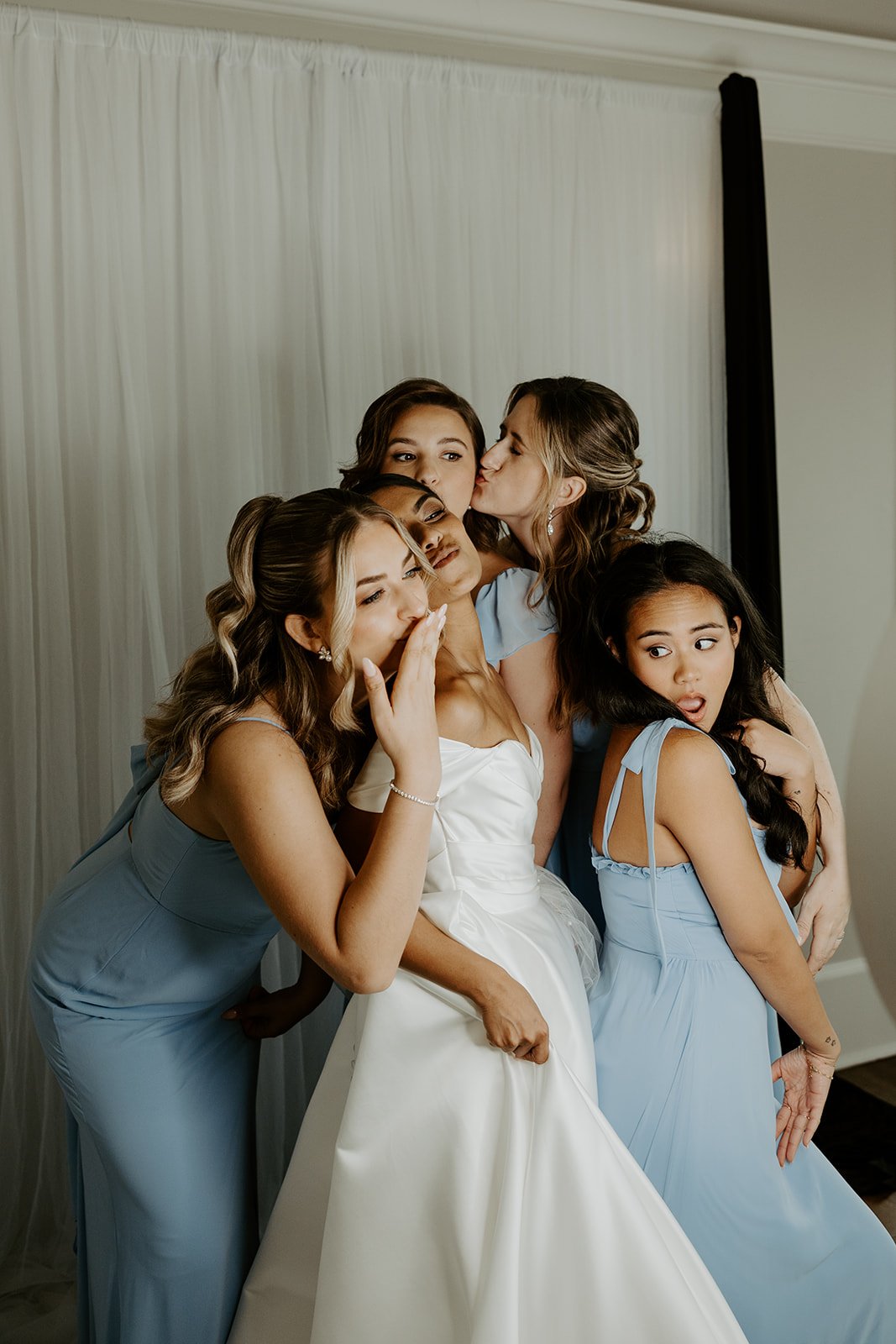 A bride taking photos with bridesmaids at a wedding photo booth