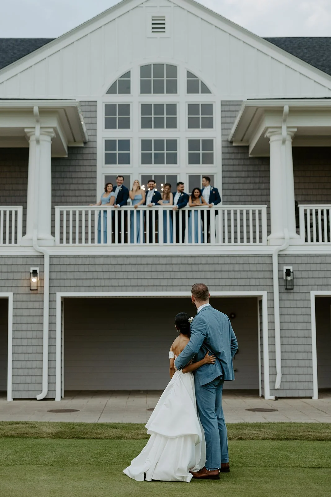 A bride and groom looking up at their bridal party