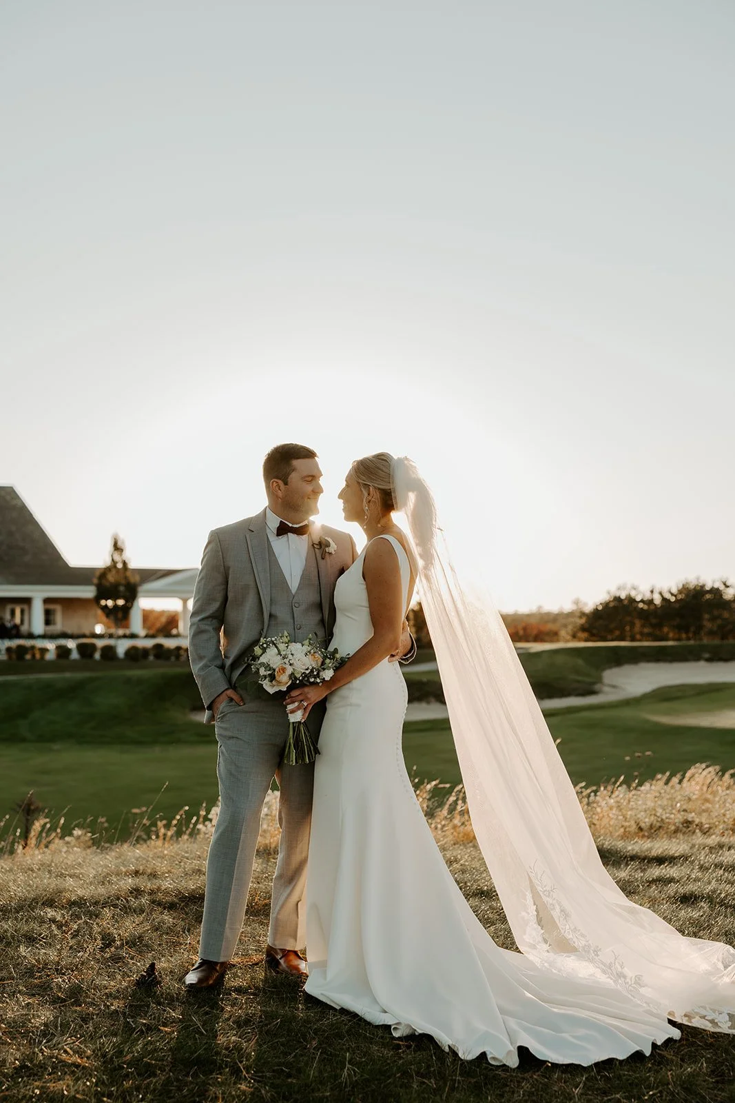 A bride and groom posing for sunset photos