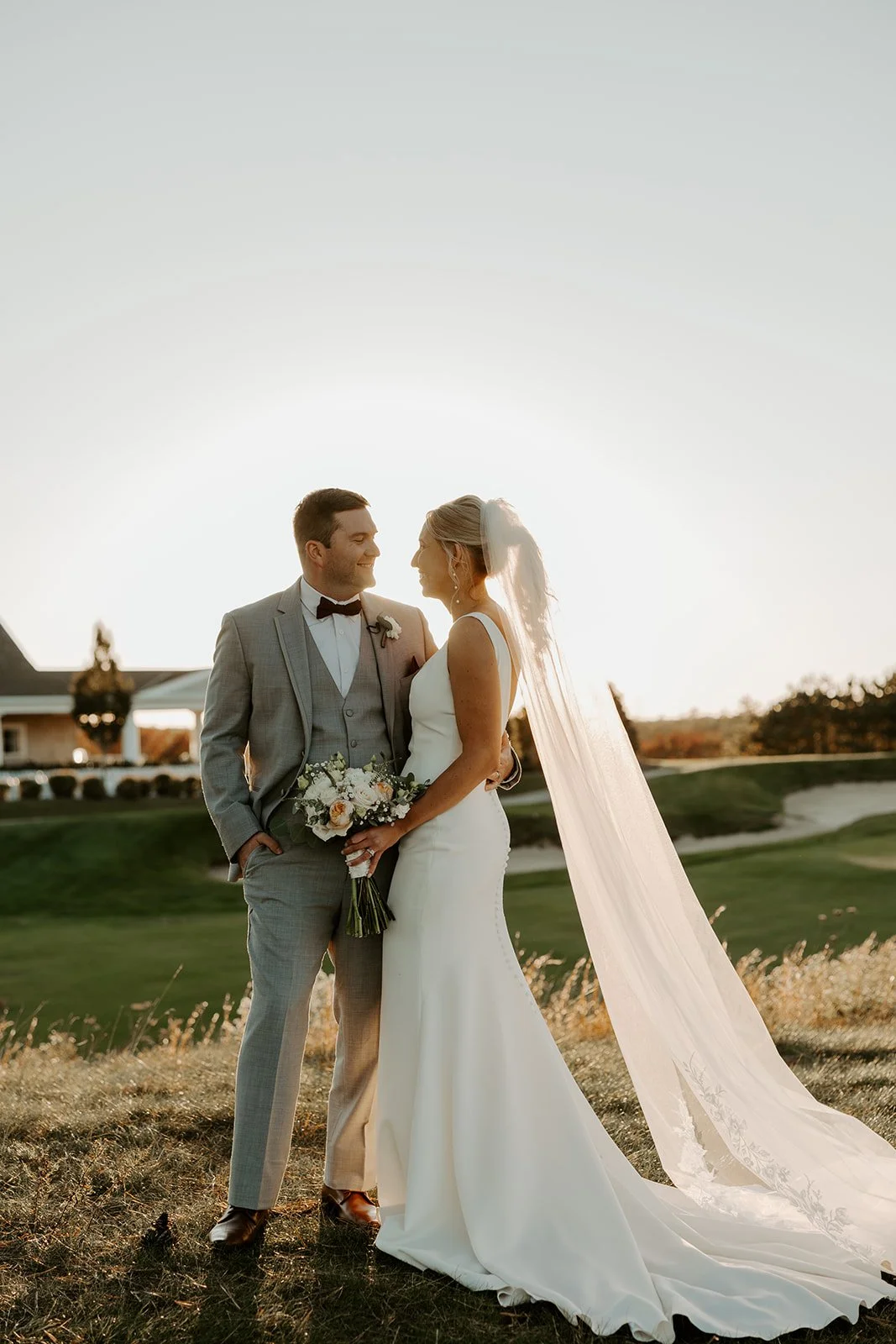 A bride and groom posing for sunset photos