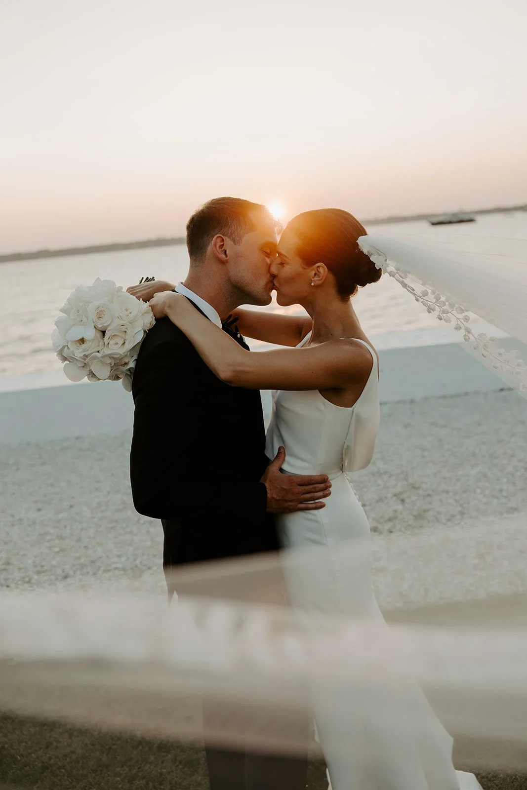 A bride and groom taking sunset photos at Rhode Island wedding venue Belle Mer