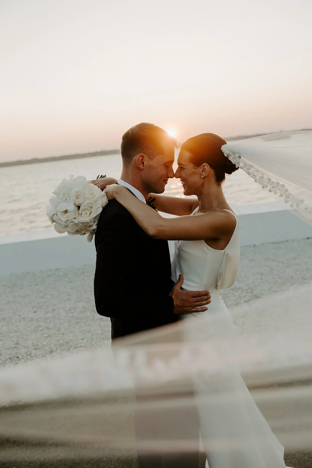 A bride and groom taking sunset photos at Rhode Island wedding venue Belle Mer