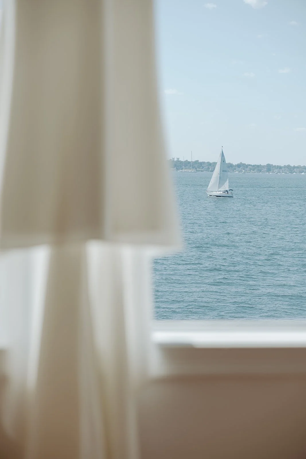 A sailboat in the background of a getting ready suite at Belle Mer