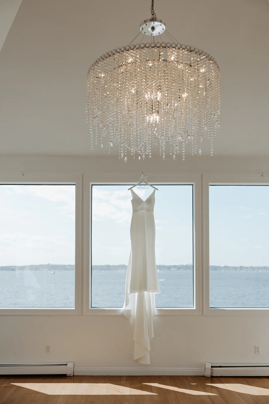 A wedding dress hanging up in a getting ready suite at belle mer