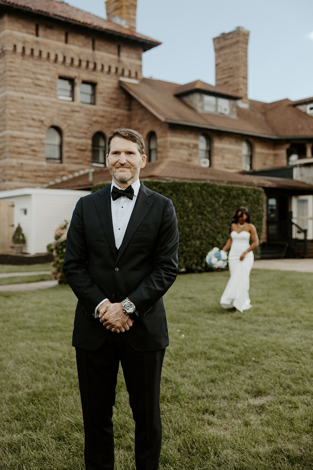 A bride walking towards a groom for a first look at Rhode Island wedding venue Oceancliff Hotel