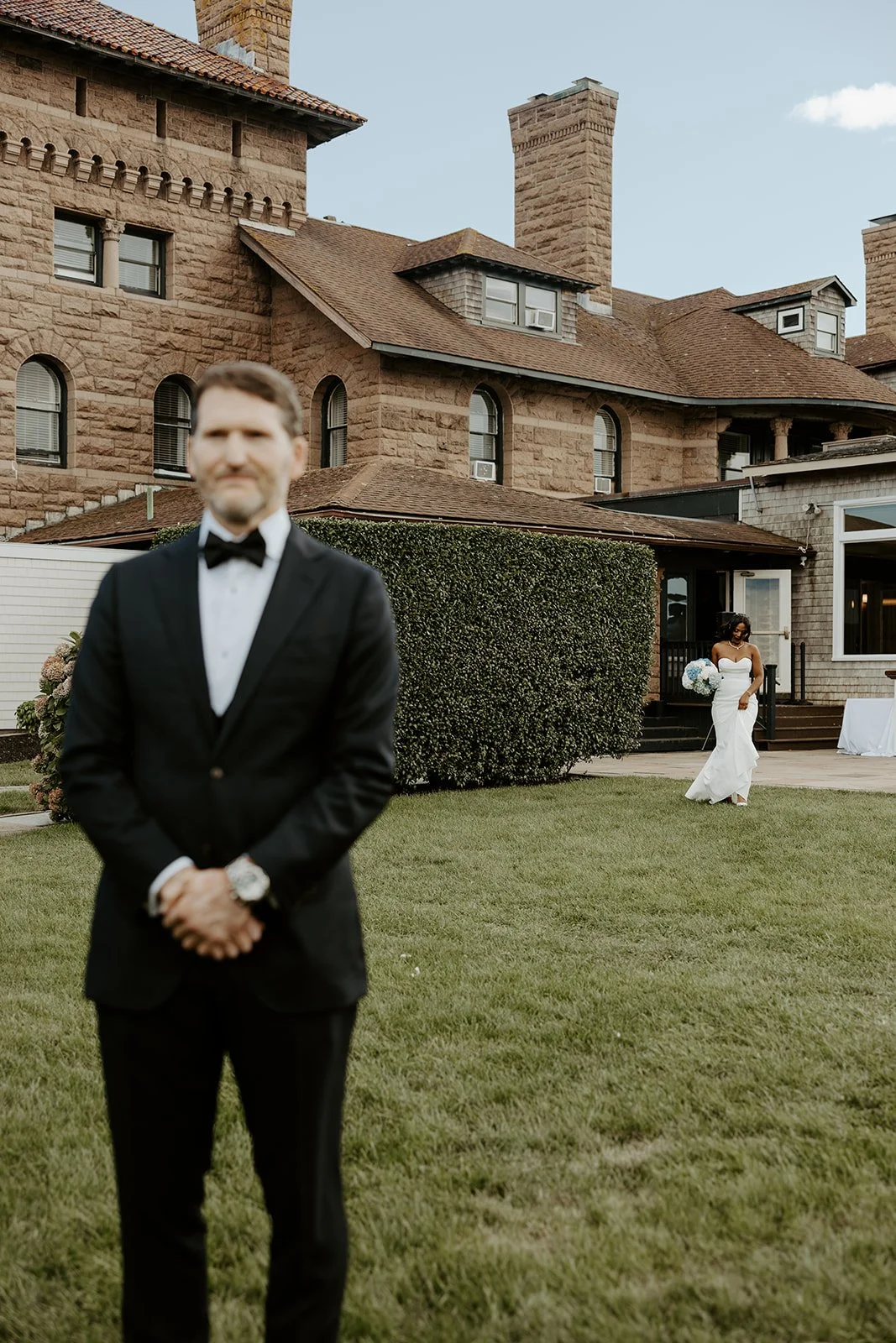A bride walking towards a groom for a first look at Rhode Island wedding venue Oceancliff Hotel