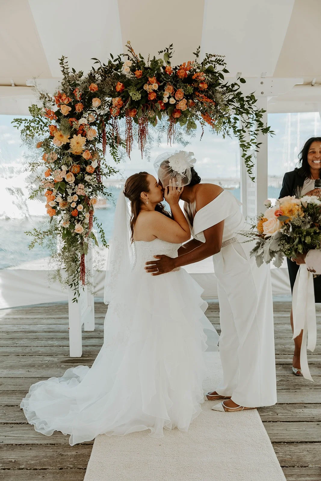 Two brides kissing at their wedding ceremony
