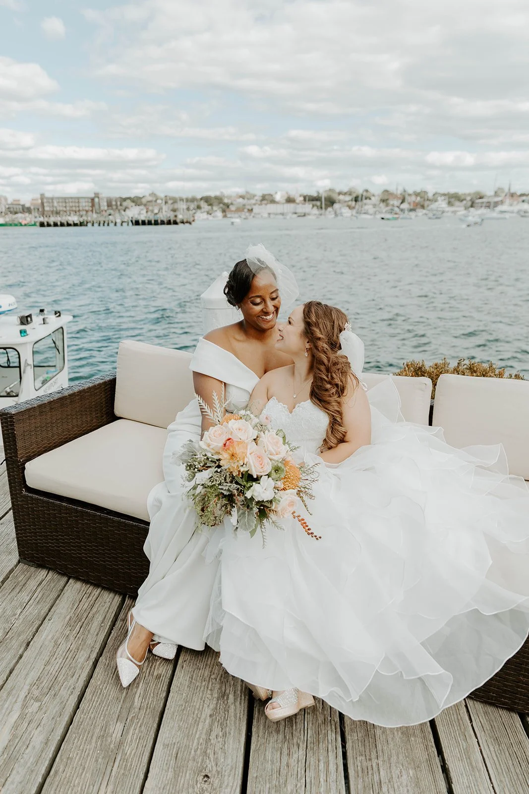 Two brides leaning in for a kiss during wedding portraits