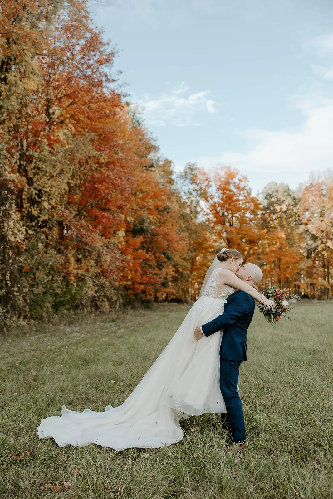 A groom picking up and kissing a bride at valley view farm
