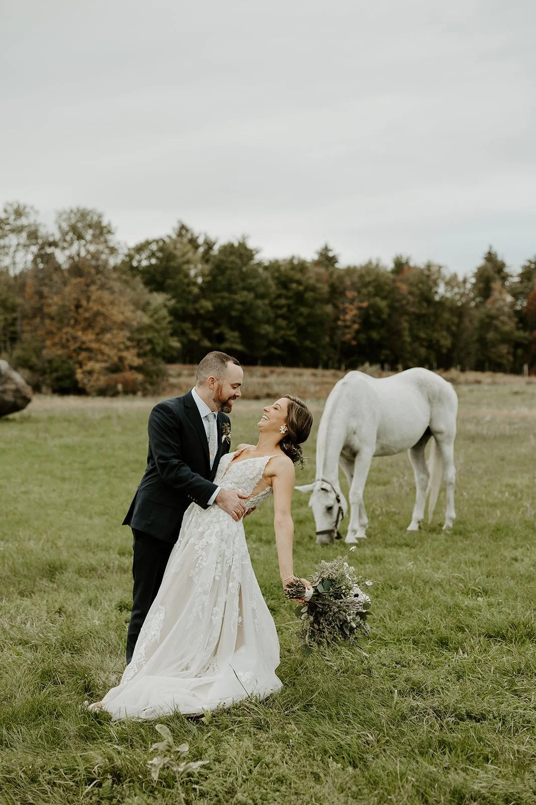 A bride and groom kissing in front of horses at valley view farm