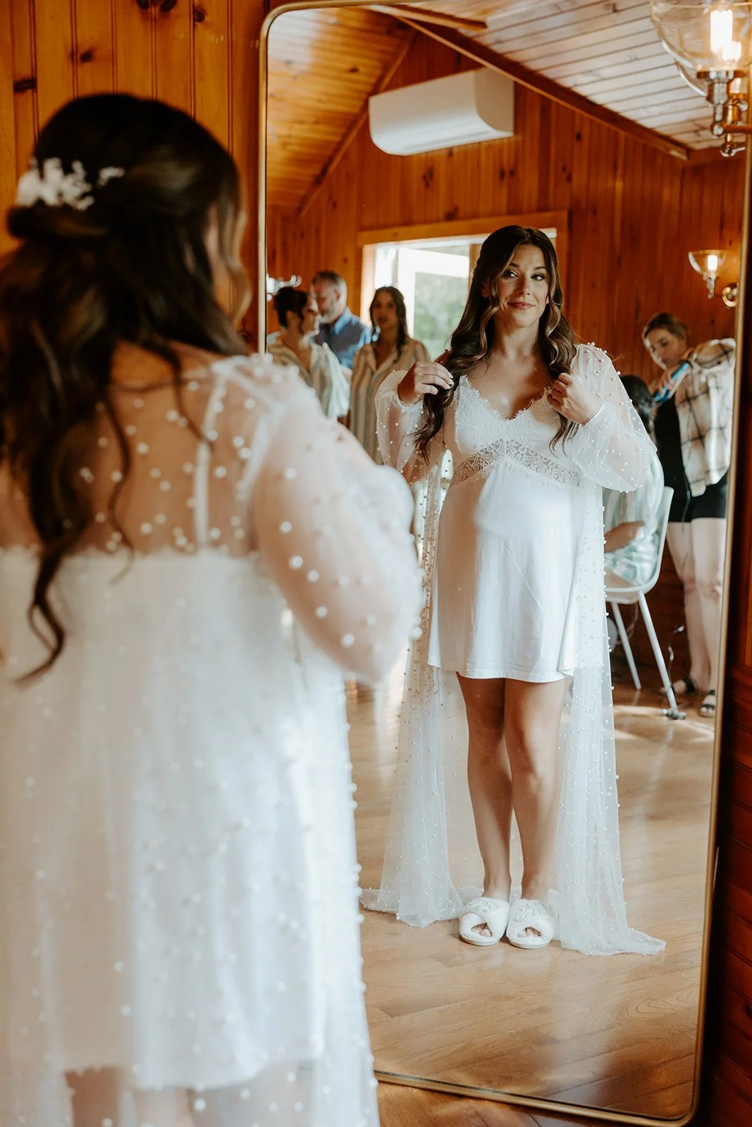 A bride looking in the mirror while getting ready for her wedding