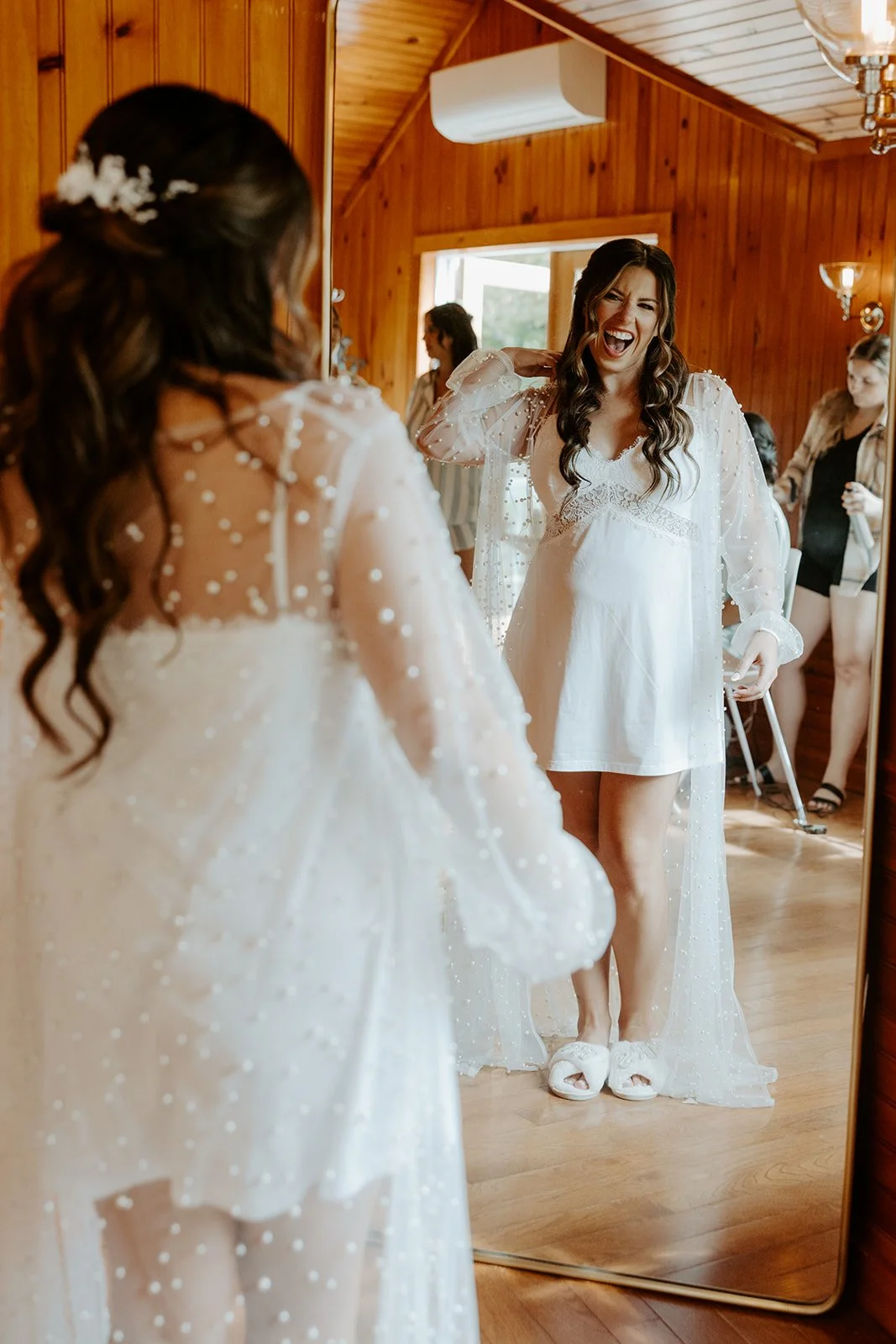 A bride looking in the mirror while getting ready for her wedding