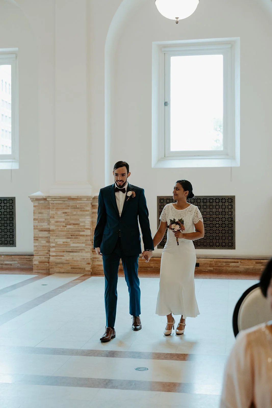 A bride and groom posing for wedding photos at their Boston Public Library elopement