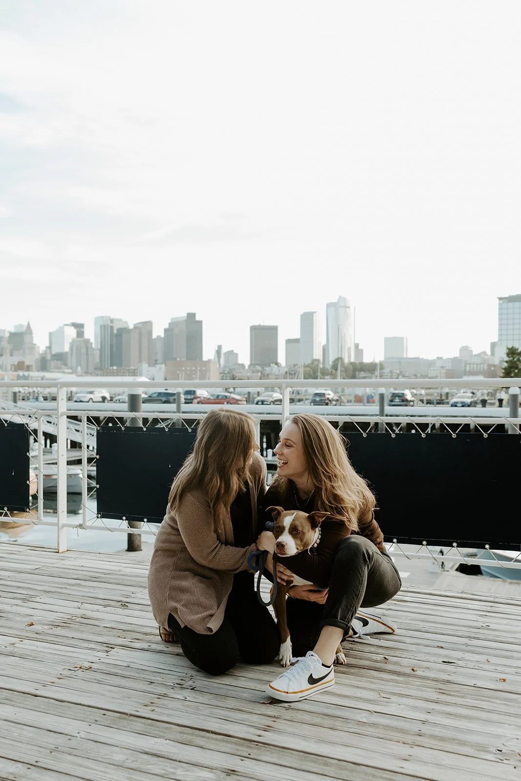 A couple posing for engagement photos in Charlestown, Boston with their dog